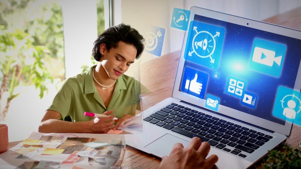 Persona trabaja en marketing digital con una laptop que muestra íconos de redes sociales