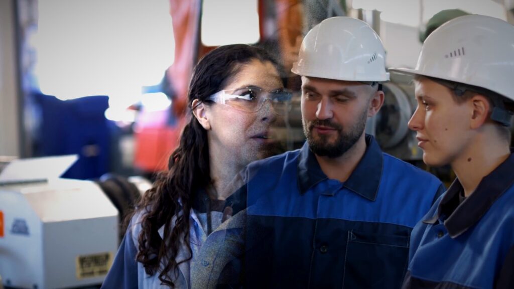 Operarios con casco conversan durante su turno en una planta industrial