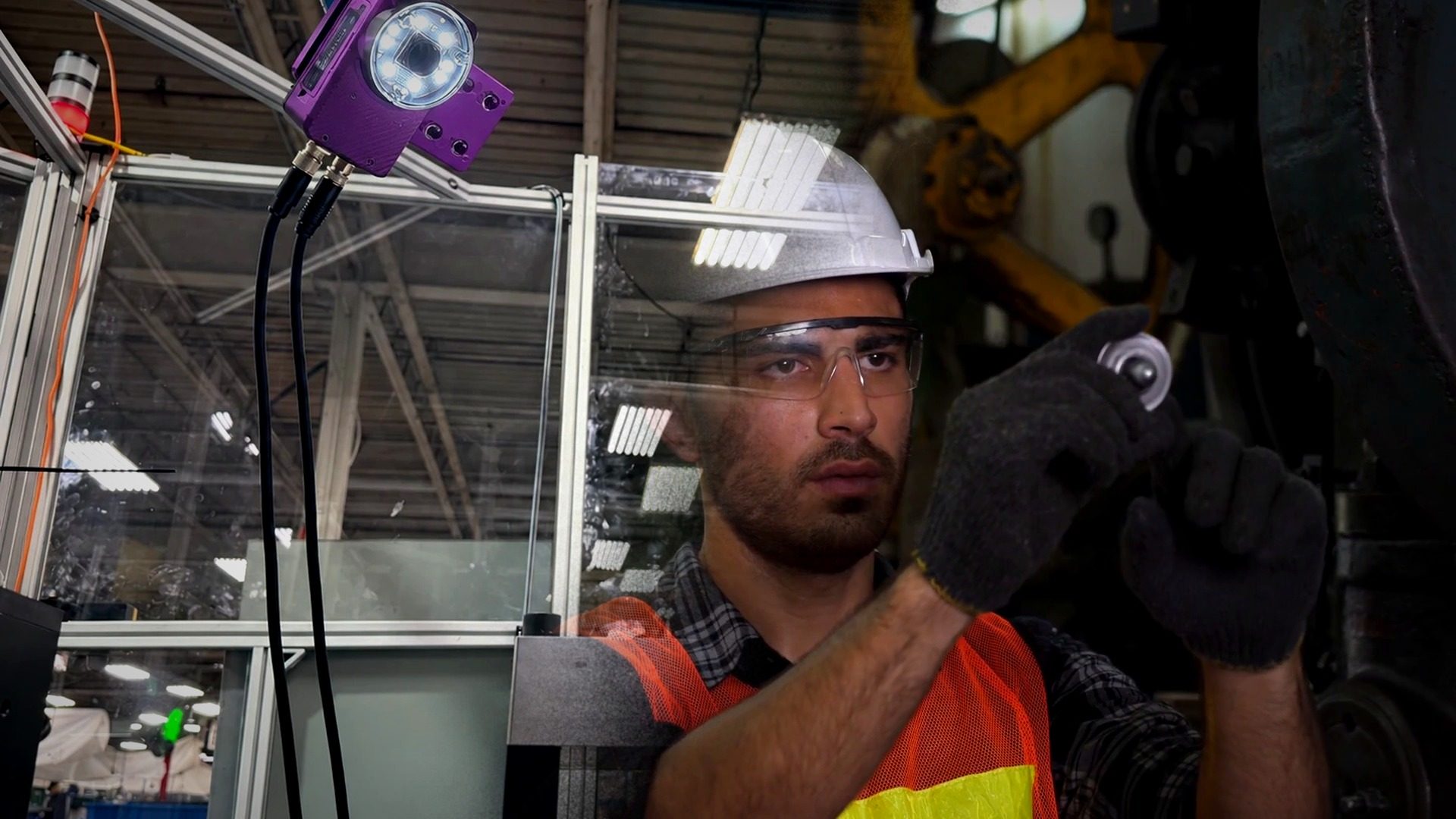 Cámara de inspección industrial junto a un operario que revisa una pieza metálica